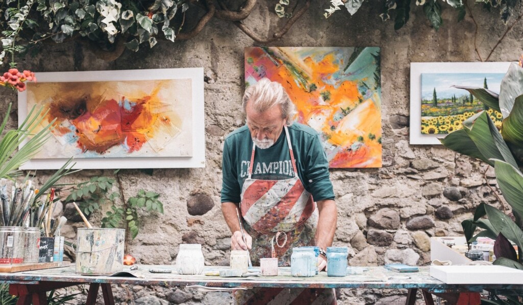 man in white and red apron holding paint brush