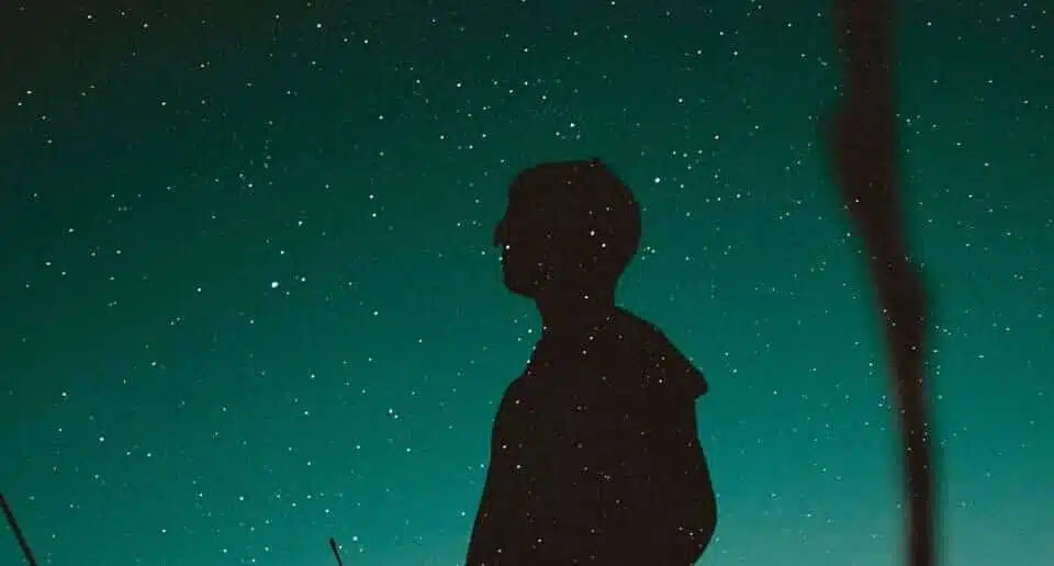 silhouette of standing man under blue sky