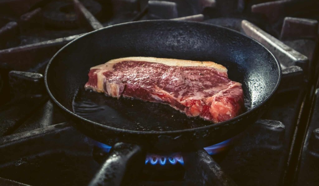 raw meat on black frying pan