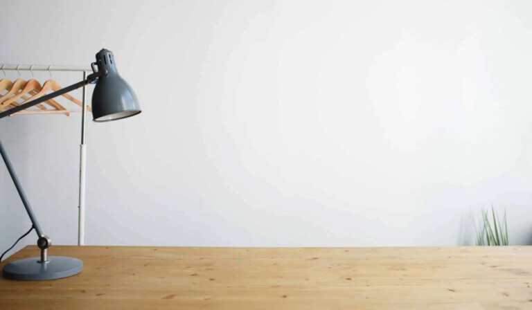 gray balanced-arm lamp on brown wooden table