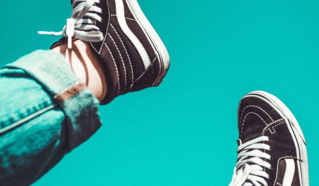 person wearing black-and-white Vans Sk8-Hi sneakers