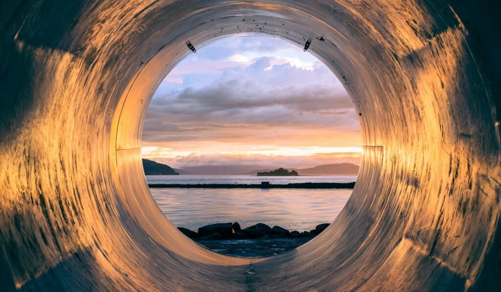 body of water can be seen through the tunnel