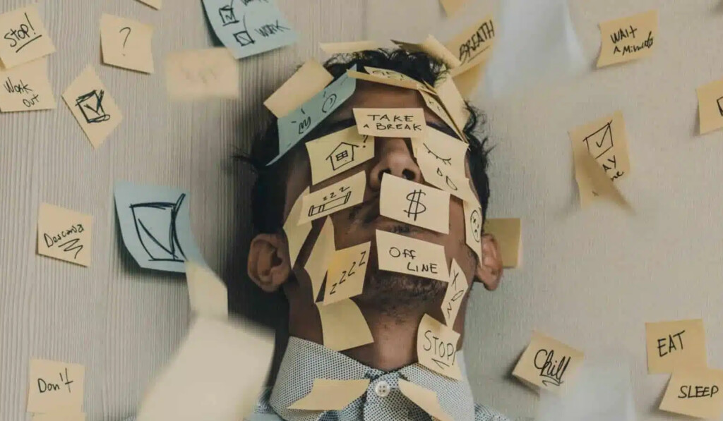 uomo stressato con blocchi per appunti incollati su tutta la faccia