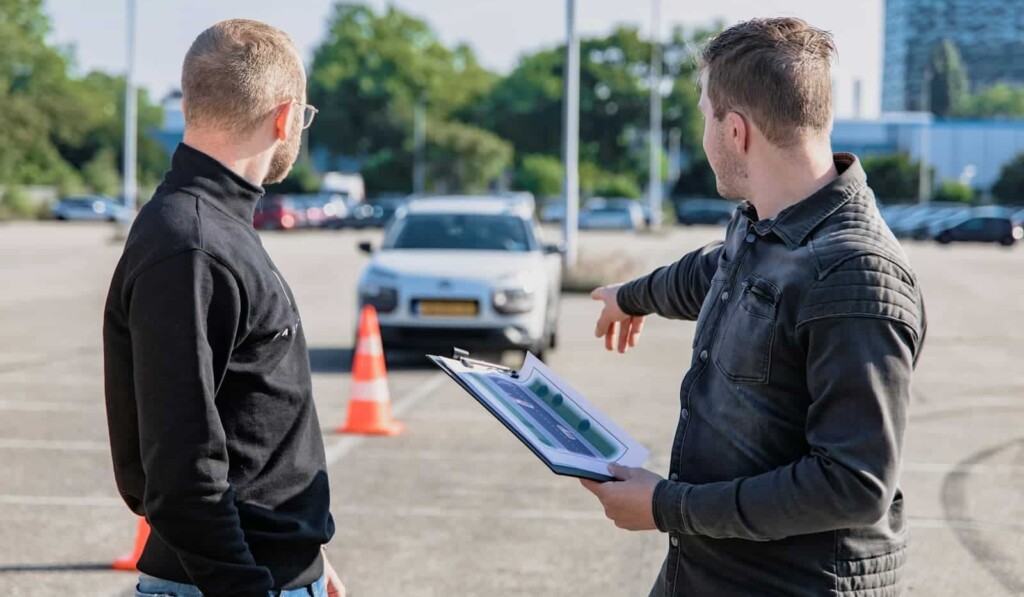 moški v črni jakni z modrim tabličnim računalnikom v roki